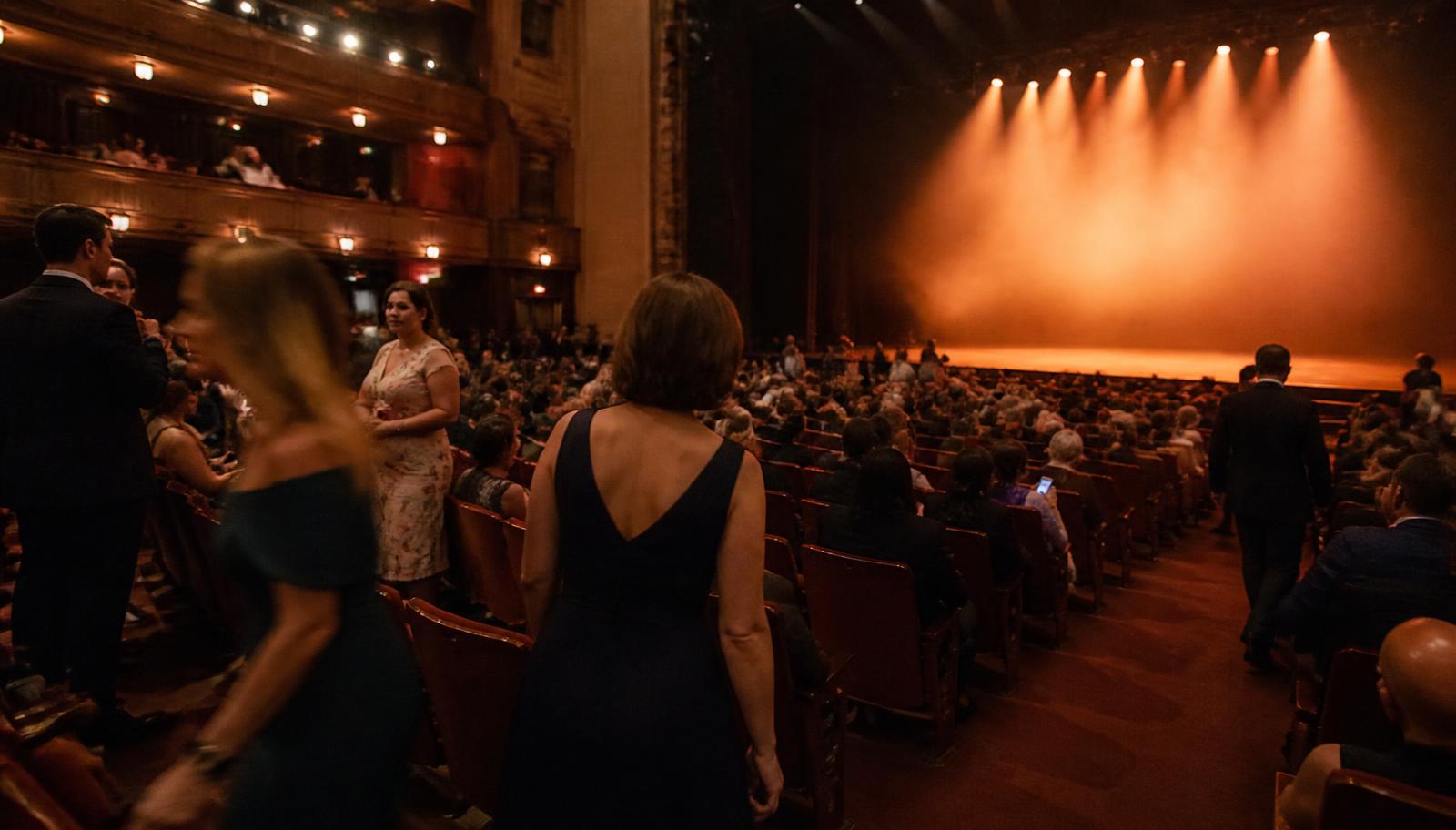 Guests taking their seats in a theatre before an evening show begins